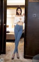 A woman standing in front of a door in a hotel room.