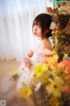 A woman sitting in front of a bunch of flowers.