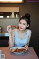 A woman sitting at a table with a plate of food.