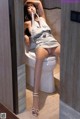 A woman sitting on a toilet in a bathroom.