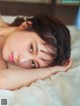 A woman laying on top of a bed with her eyes closed.