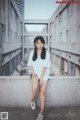 A woman sitting on top of a concrete wall.