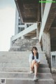 A woman sitting on the steps of an abandoned building.