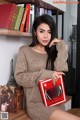 A woman sitting on a table holding a book.