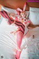 A woman in a bunny costume laying on a bed.