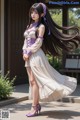 A woman with long black hair wearing a white dress and purple shoes.