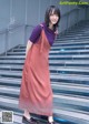 A woman in a red dress standing on some steps.