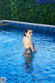 A woman in a bikini standing in a swimming pool.